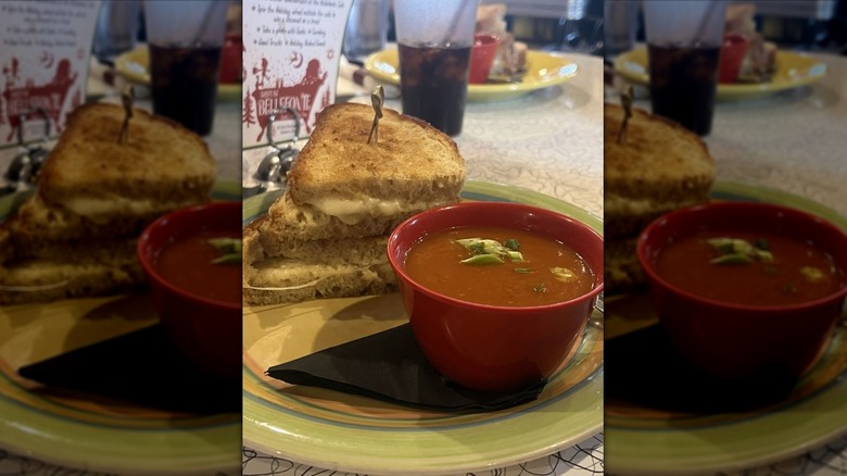 Grilled cheese on a plate alongside a bowl of soup