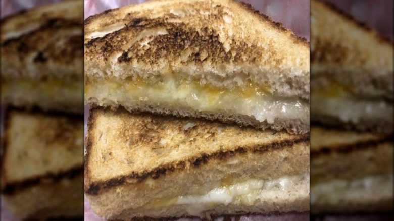 Two halves of a grilled cheese sandwich stacked atop one another
