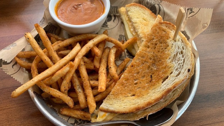 Grilled cheese on plate with fries and dipping sauce