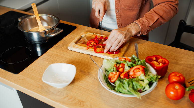 masterchef making food on cutting board with stove and veggies