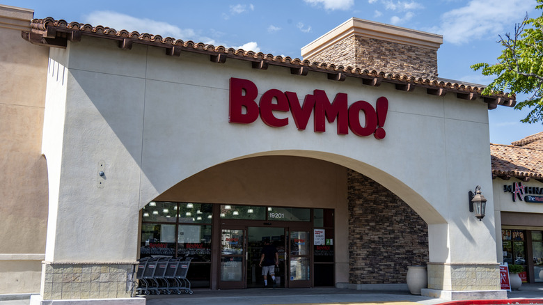 A wide shot showing the entrance to a BevMo store with a customer walking in