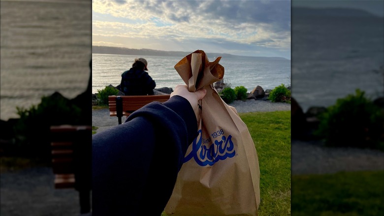 Ivars fish and chips bag held at the beach