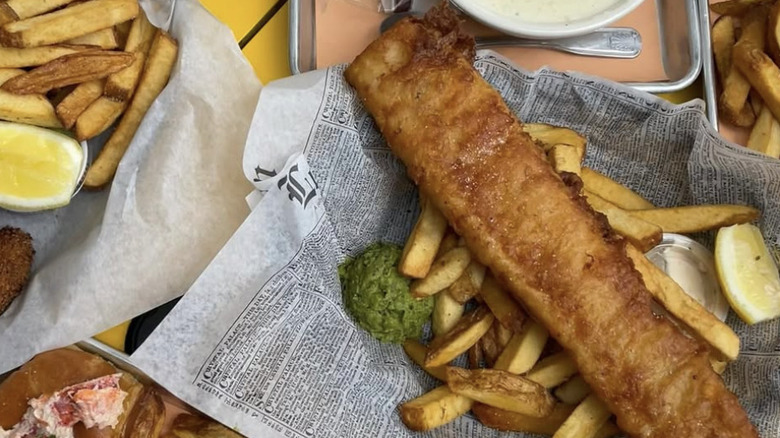 Fish and chips with mushy peas on newspaper
