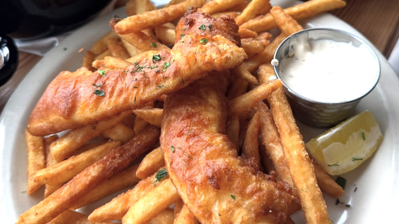 Fish and chips with tartar sauce on a white plate