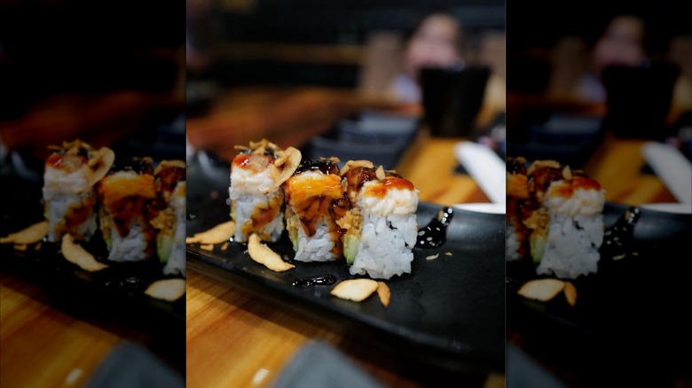 sushi rolls plated on a black dish