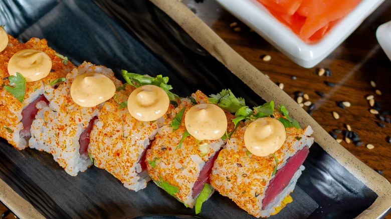 Top view of tuna rolls on black plate