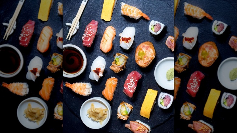 Top view of various nigiri and rolls on a table with ginger and soy sauce