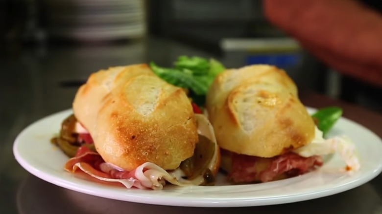 Two halves of an Italian sub on a white plate still from DDD