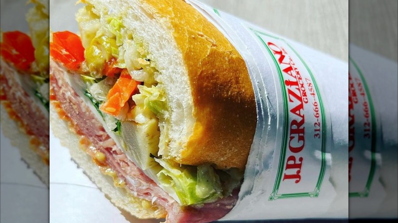 Half an Italian sub wrapped in paper with JP Graziano's label