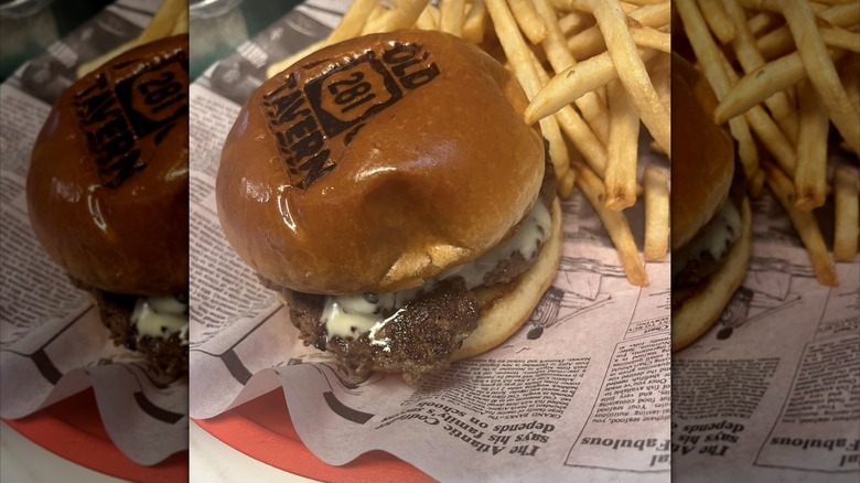 Burger with fries on newspaper