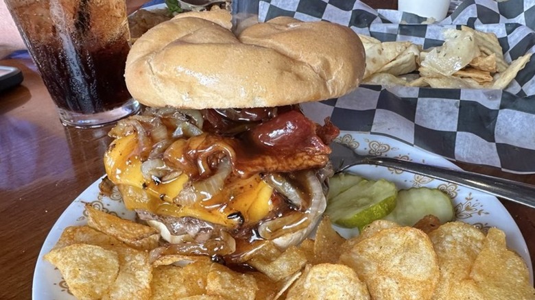 Burger with fries and pickles on a plate