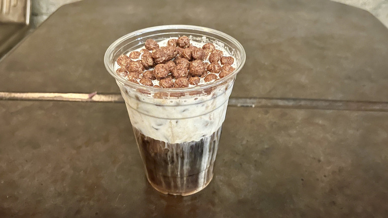 Cold brew black caf drink with chocolatey cereal on top