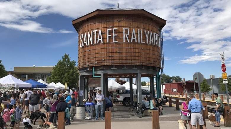 Shoppers enjoying farmers market underneath Santa Fe Railyard tower
