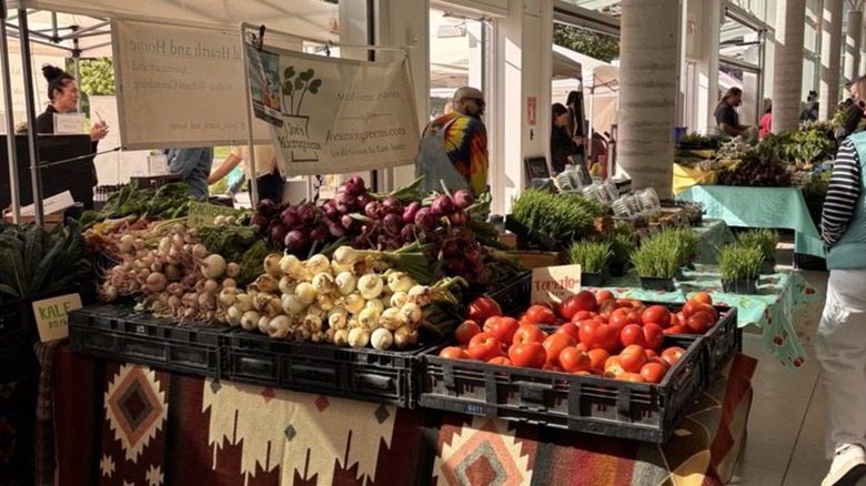Tomatoes, root vegetables, kale, and more lining farmers market tables