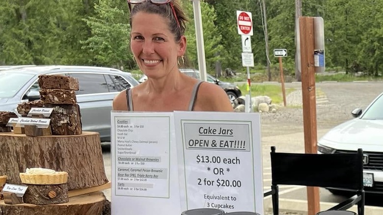 Woman smiling behind booth selling award-winning cake jars