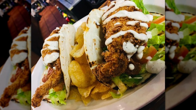 Close-up of plate of chicken bacon ranch wraps with chips on white plate