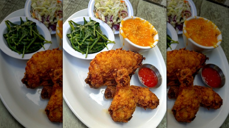 White plate of fried chicken, collards, coleslaw, mac and cheese, small ketchup cup