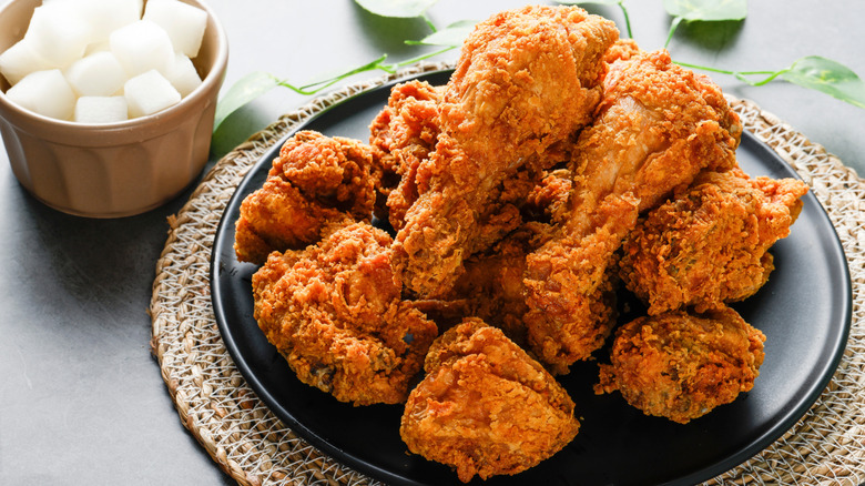 Fried chicken pieces on black plate