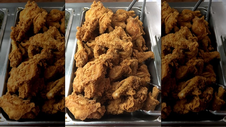 Fried chicken sitting in warmer tray on buffet line