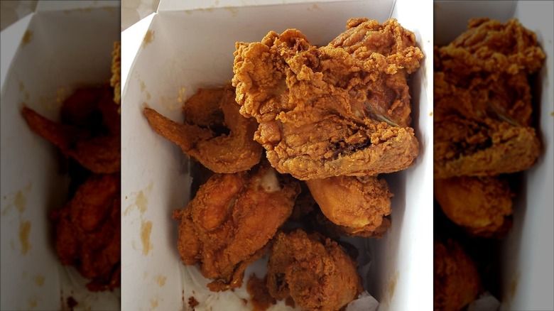 Fried chicken pieces in white takeaway container