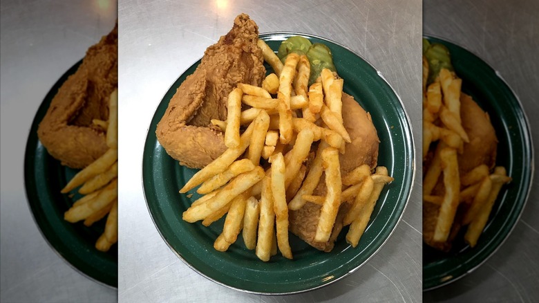 Top-down shot of fried chicken and French fries on green plate