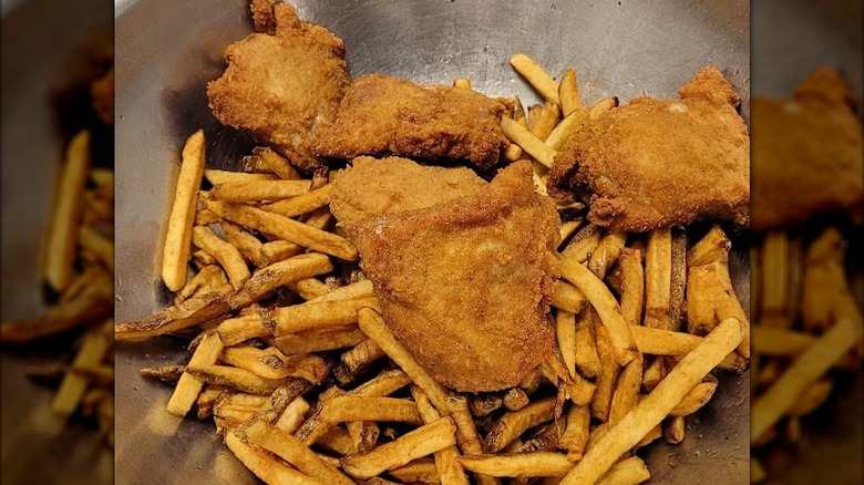 Large metal bowl of fried chicken and french fries