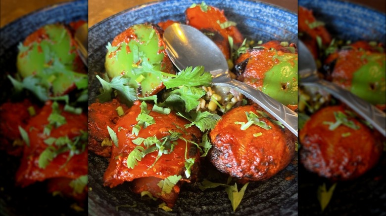 Spicy mushrooms garnished with cilantro on elegant plate with spoon
