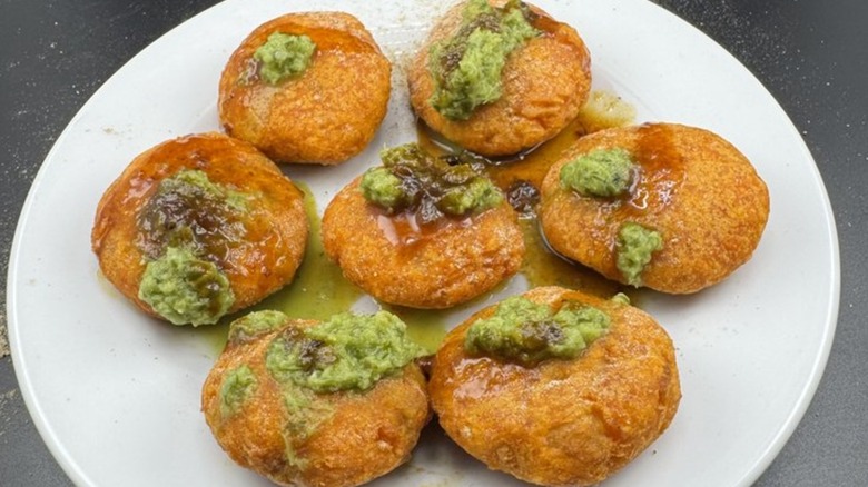 Puri shells filled with tamarind and mint chutneys