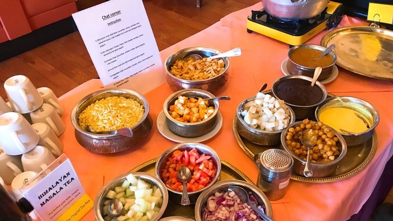 Table topped with chaat ingredients for customers to assemble their own plates