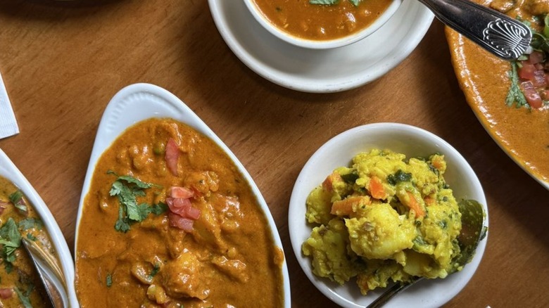 Overhead shot of various curries and cooked vegetables in bowls