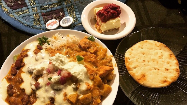 Several items from buffet on plate alongside flatbread and dessert