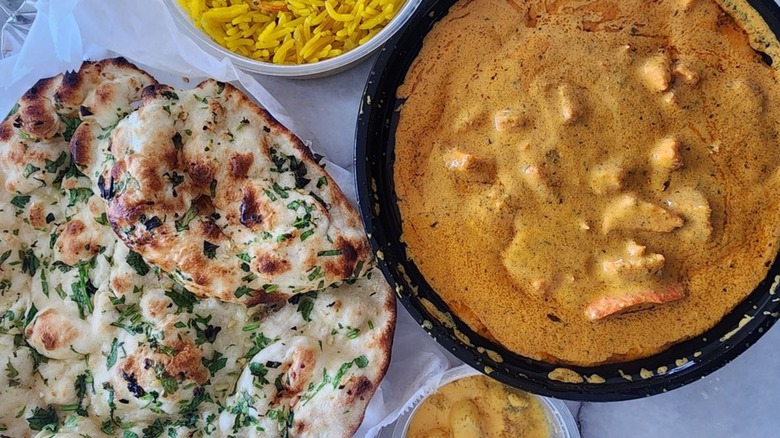 Overhead shot of lemon rice, naan, and butter chicken