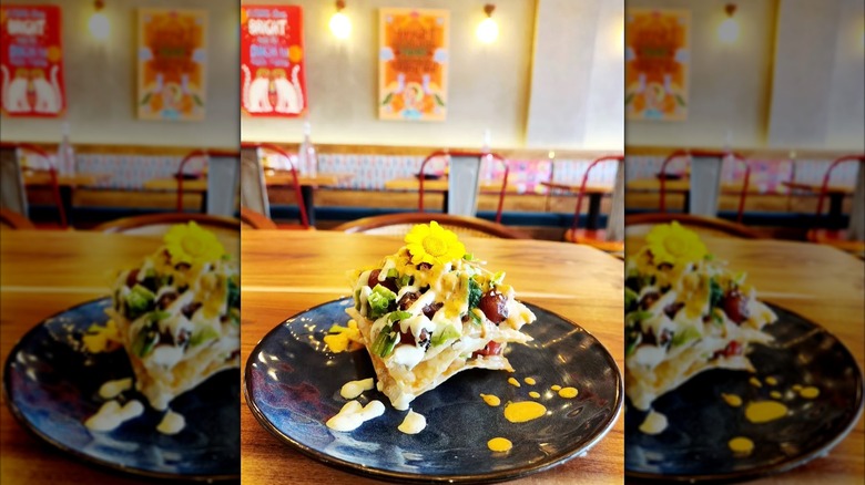 Indian food on black plate with colorful art behind