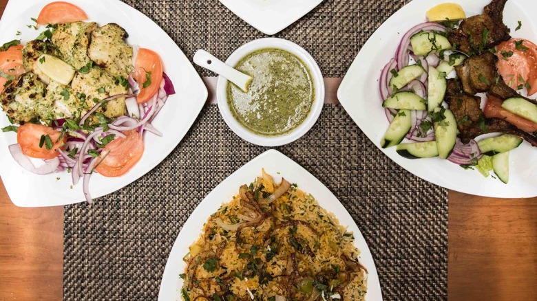 Indian foods on three white plates