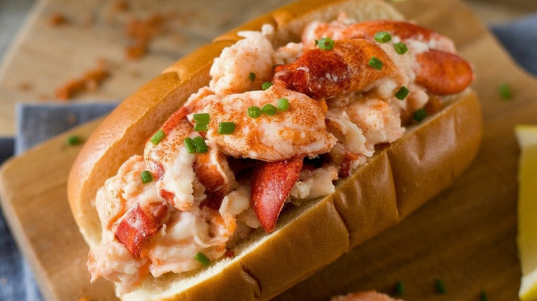 Buttery lobster with chives roll on wooden board