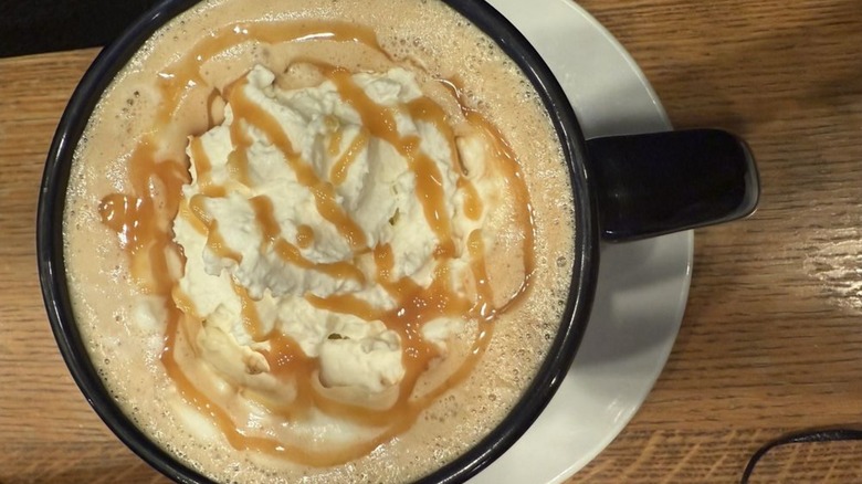 Overhead shot of pumpkin spice latte in mug, topped with whipped cream