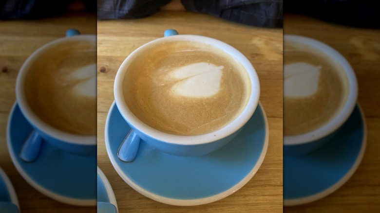 Pumpkin spice latte in mug on saucer, along with spoon