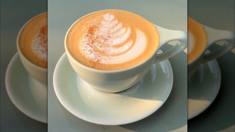 Pumpkin spice latte sprinkled with spice in mug