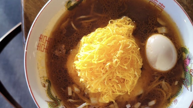 Cincinnati-style chili ramen with chili broth, ground pork, tamago, white onion, and shredded cheddar