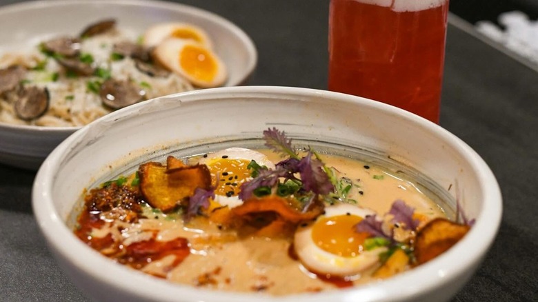 Bowl of creamy ramen, with beverage