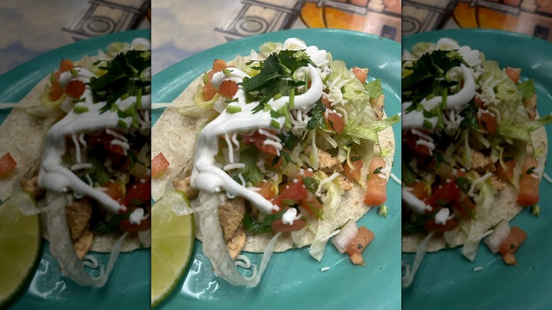 Taco with sour cream on teal plate