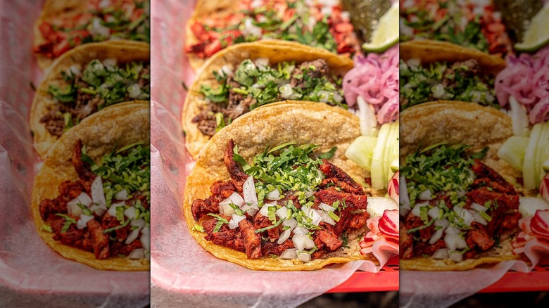Three street tacos on wax paper in basket