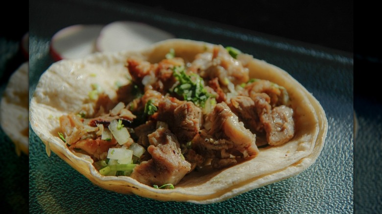 Close-up of chicken soft taco on textured surface