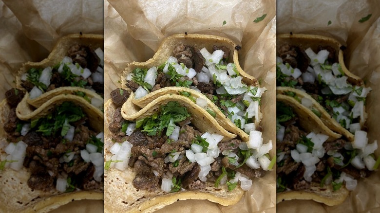 A close-up, overhead shot of beef soft tacos with cilantro and onion
