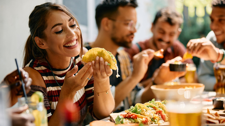 Woman happily looking at a delicious taco