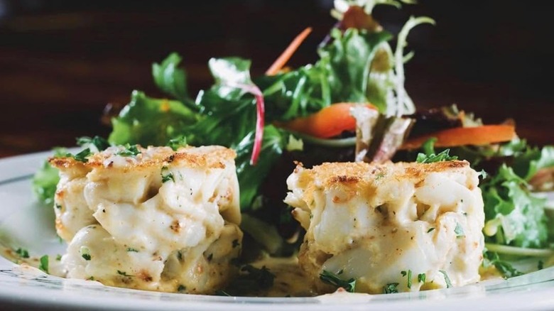 Two crab cakes with greens