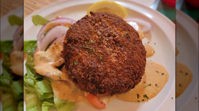 Crab cake with sauce and greens