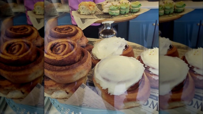 Overhead shot of two cinnamon rolls on plate, one frosted and one plain