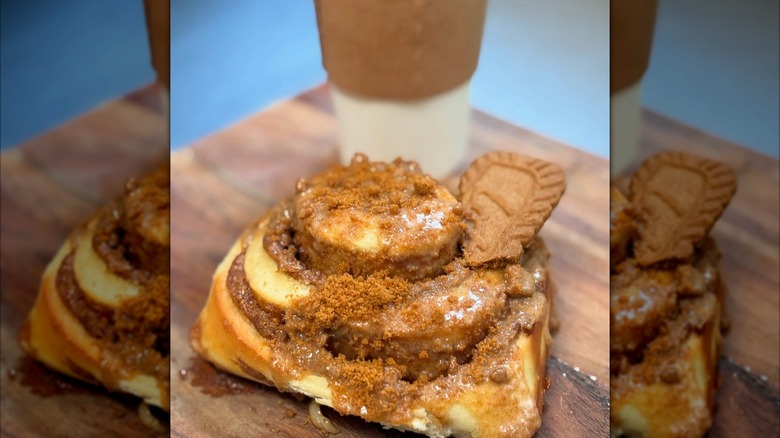 Biscoff cookie cinnamon roll in front of coffee cup