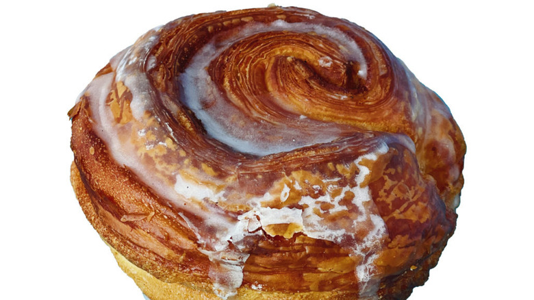 Glazed cinnamon roll on plain white background
